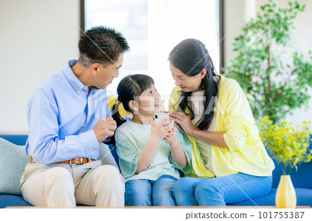 Grandchildren and grandparents looking at smartphones 101755387