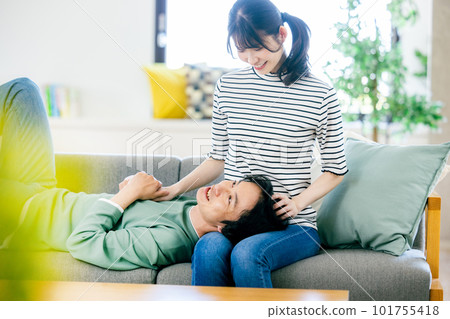 A young couple relaxing in the living room 101755418
