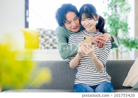 看智能手機的年輕夫婦 101755420