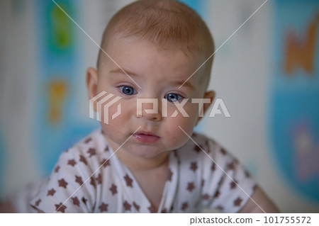Portrait of a cute baby girl lying on the floor with toys. 101755572
