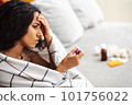 Young Arab woman gets sick and looks at the thermometer. 101756022
