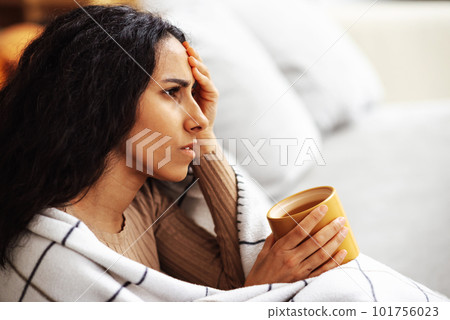 After a hard day at work, a woman experiences stress and headache. 101756023
