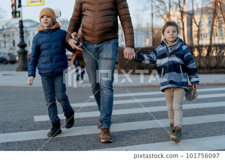 father and children crossing road on pedestrian crosswalk 101756097
