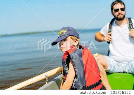 caucasian bearded man and litle boy floating on rowboat in lake caucasian bearded man and litle boy floating on rowboat in lake 101756132