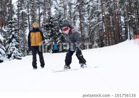 little boy learning to ride on snowboard little boy learning to ride on snowboard 101756138