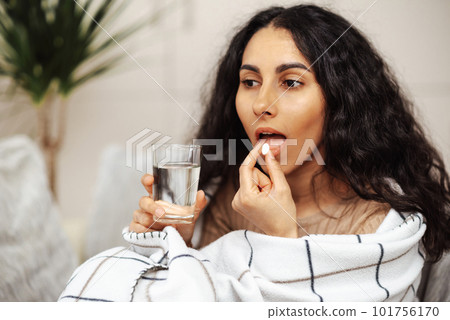 Pretty young woman taking medicine. Pill as a means for treatment or beauty. Pretty young woman taking medicine. Pill as a means for treatment or beauty. 101756170