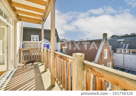a balcony with some houses in the background and a blue sky above it, as seen from an apartment window a balcony with some houses in the background and a blue sky above it, as seen from an apartment window 101756320