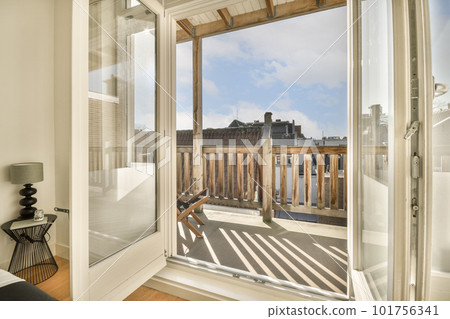 a bathroom with a view out to the city from it's sliding glass door, and there is a chair in the corner 101756341