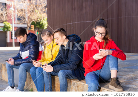 Teenagers chatting on their smartphone on walking Teenagers chatting on their smartphone on walking 101756930