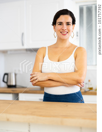 Portrait of girl housewife standing at home kitchen Portrait of girl housewife standing at home kitchen 101757392