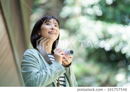 A woman walking in fresh greenery A woman enjoying sightseeing A woman walking in a tourist spot A woman traveling on a holiday 101757548