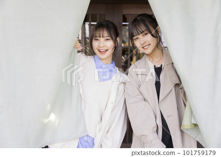 Image of a girls' trip A young woman sticking her head out from the curtain of a hot spring inn 101759179