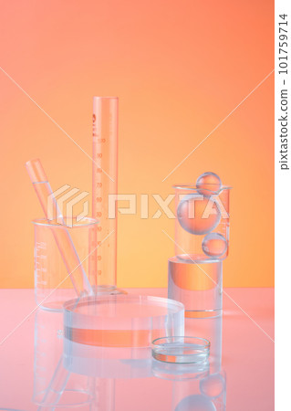 Lab theme with test tubes, beaker, petri dish and glass ball decorated on orange background. An empty transparent podium for display cosmetic product. Science and medical background Lab theme with test tubes, beaker, petri dish and glass ball decorated on orange background. An empty transparent podium for display cosmetic product. Science and medical background 101759714