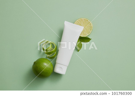 An unlabeled tube in white color displayed with Lime slices and peel. Lime (Citrus aurantiifolia) essential oil can remove dead cells that accumulate in hair follicles An unlabeled tube in white color displayed with Lime slices and peel. Lime (Citrus aurantiifolia) essential oil can remove dead cells that accumulate in hair follicles 101760300