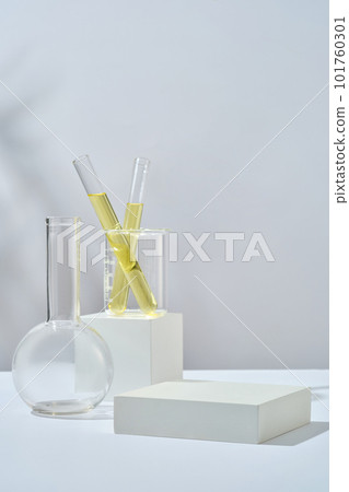Test tube containing yellow liquid inside a beaker placed on cube podium. Empty rectangle podium for beauty product promotion of Lime (Citrus aurantiifolia) extract 101760301