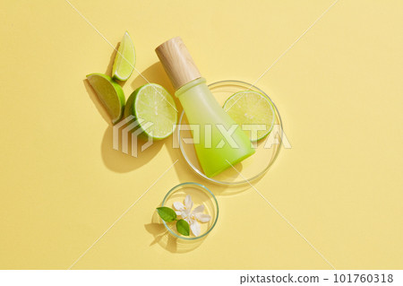 Unlabeled gradient jar with wooden cap placed on a glass petri dish with Lime slice over a pastel background. Mockup for beauty products of Lime (Citrus aurantiifolia) extract Unlabeled gradient jar with wooden cap placed on a glass petri dish with Lime slice over a pastel background. Mockup for beauty products of Lime (Citrus aurantiifolia) extract 101760318