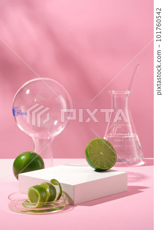 Scene for advertising product with laboratory concept - fresh limes and peel decorated on pink background with lab glassware. White empty podium for presentation cosmetic with ingredient from lime Scene for advertising product with laboratory concept - fresh limes and peel decorated on pink background with lab glassware. White empty podium for presentation cosmetic with ingredient from lime 101760542