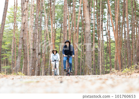 Couple riding an electric bike in the woods 101760653