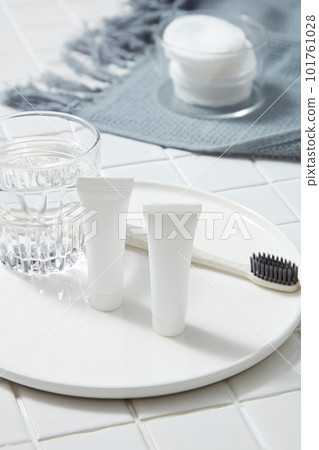 A round dish with a glass of water, unlabeled tube and a toothbrush placed on. Organic product mockup. Aloe vera (Aloe barbadensis miller) helps eliminate harmful bacteria in the mouth A round dish with a glass of water, unlabeled tube and a toothbrush placed on. Organic product mockup. Aloe vera (Aloe barbadensis miller) helps eliminate harmful bacteria in the mouth 101761028