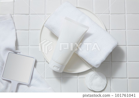 A white tube displayed with a towel, cotton pads and a handhold mirror. Empty label for cosmetic mockup of Aloe vera extract. Aloe vera (Aloe barbadensis miller) unclogs the pores and softens the skin A white tube displayed with a towel, cotton pads and a handhold mirror. Empty label for cosmetic mockup of Aloe vera extract. Aloe vera (Aloe barbadensis miller) unclogs the pores and softens the skin 101761041