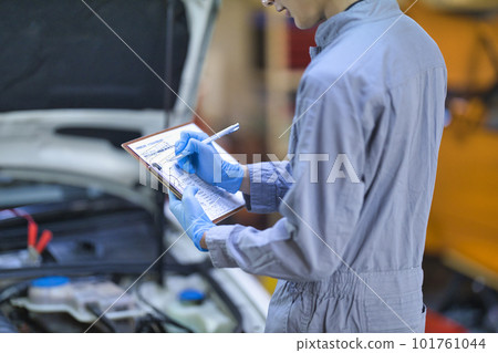 檢查引擎蓋里面的汽車機械師 101761044