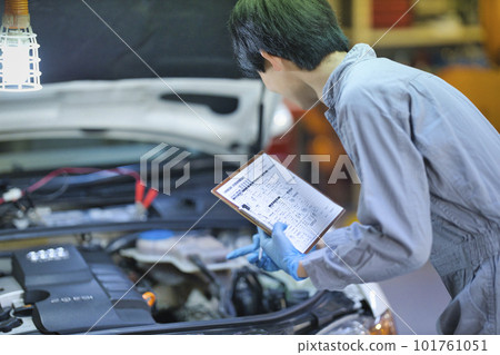 Auto mechanic checking inside the hood Auto mechanic checking inside the hood 101761051