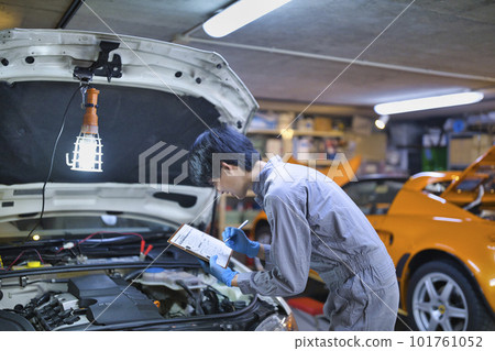 檢查引擎蓋里面的汽車機械師 101761052