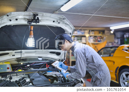 檢查引擎蓋里面的汽車機械師 101761054