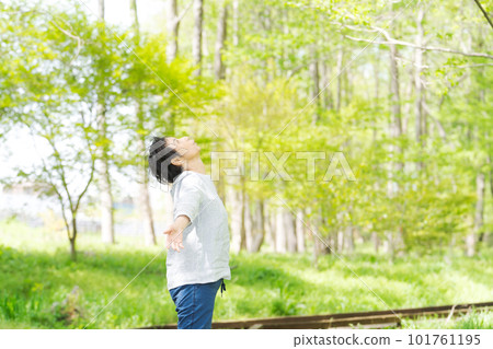 一位高級女性在清新的綠色公園裡放鬆的形象 101761195