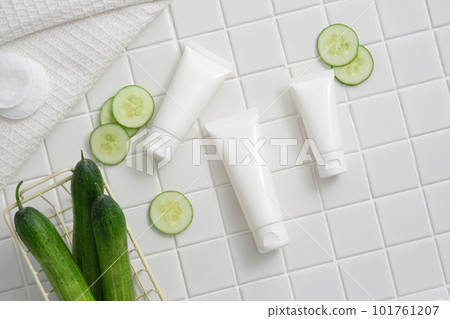 A basket of Cucumber arranged with unlabeled tubes, Cucumber slices and cotton pads. Cucumber (Cucumis sativus) helps combat premature aging. Skin care product mockup A basket of Cucumber arranged with unlabeled tubes, Cucumber slices and cotton pads. Cucumber (Cucumis sativus) helps combat premature aging. Skin care product mockup 101761207