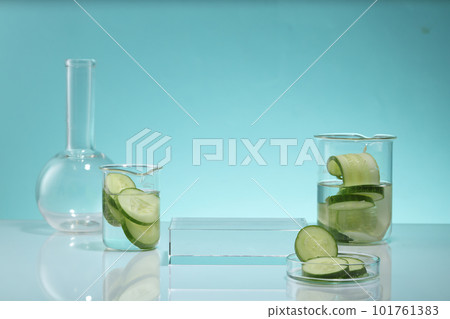 Cucumber slices contained in glass petri dish and beakers. A rectangle podium with empty space for product promotion. Cucumber (Cucumis sativus) extract is a safe ingredient used in cosmetics Cucumber slices contained in glass petri dish and beakers. A rectangle podium with empty space for product promotion. Cucumber (Cucumis sativus) extract is a safe ingredient used in cosmetics 101761383