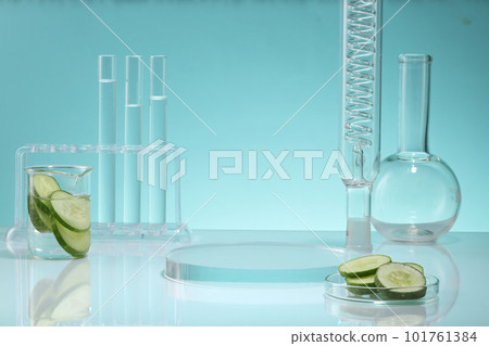 Research content with beaker and petri dish containing Cucumber slices and other laboratory glassware. Round transparent podium displayed. Cucumber (Cucumis sativus) has anti-inflammatory properties 101761384