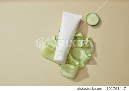 A white plastic tube unlabeled decorated with fresh cucumber slices on beige background. Mockup for cleansing and moisturizing cucumber cosmetics. Natural organic ingredient to homemade beauty product A white plastic tube unlabeled decorated with fresh cucumber slices on beige background. Mockup for cleansing and moisturizing cucumber cosmetics. Natural organic ingredient to homemade beauty product 101761447