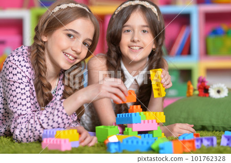 Two girls playing with colorful plastic blocks Two girls playing with colorful plastic blocks 101762328
