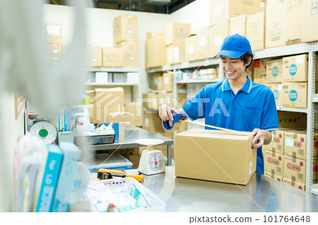Young man packing in warehouse Young man packing in warehouse 101764648