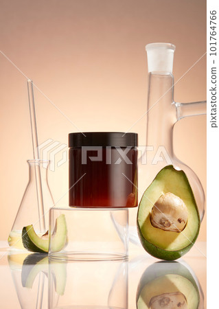 Laboratory concept with some glassware displayed with Avocado slices and a jar without label. Promotion of beauty product extracted from Avocado (Persea americana), contains vitamin C and E Laboratory concept with some glassware displayed with Avocado slices and a jar without label. Promotion of beauty product extracted from Avocado (Persea americana), contains vitamin C and E 101764766