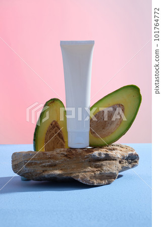 A white tube pouted on a stone with Avocado slices. Branding mockup. The natural oil in Avocado (Persea americana) can penetrate deep into the skin to nourish and hydrate it A white tube pouted on a stone with Avocado slices. Branding mockup. The natural oil in Avocado (Persea americana) can penetrate deep into the skin to nourish and hydrate it 101764772