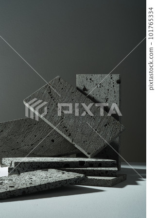 The dark rectangle stones are randomly decorated and arranged on a dark background. Empty space for display cosmetic product. Minimal style, front view, copy space. 101765334