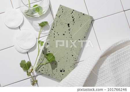 Blank background for display product with gray brick podium, gotu kola leaves and cotton pad on white tile background. Bathroom concept for advertising. Space to placed your design 101766246