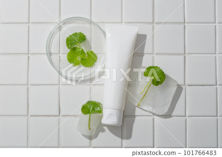 Empty label cosmetic container arranged with frozen Gotu kola leaves. Blank empty to promote cosmetic product extracted from Gotu kola (Centella asiatica) 101766483