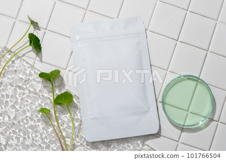 Unbranded facial skin care mask decorated with acrylic sheet and a glass petri dish filled with green fluid. Concept of natural and organic beauty products 101766504