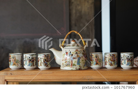 side view one ceramic kettle and six ceramic cups on glass and wood cabinet, object, decor, kitchen, copy space side view one ceramic kettle and six ceramic cups on glass and wood cabinet, object, decor, kitchen, copy space 101767960