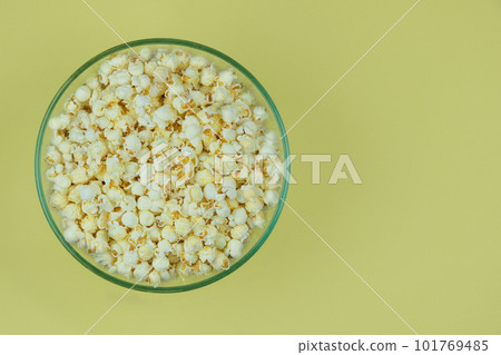 Popcorn large bowl on a yellow background. Fast food for cinema. Top view. 101769485