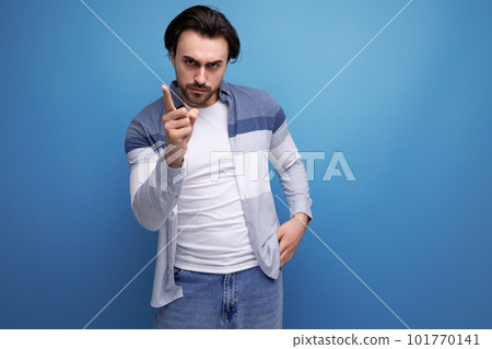 nice brunette guy in casual style shows with his hand for having an idea on a studio background 101770141
