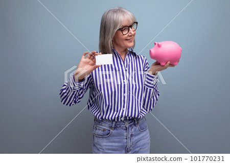 pension contribution. middle-aged woman with gray hair masters cashless payments holding a credit pension contribution. middle-aged woman with gray hair masters cashless payments holding a credit 101770231