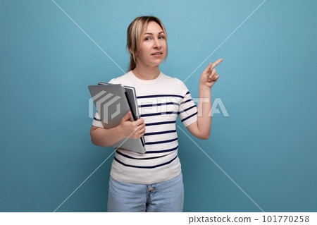 close-up of a successful blonde woman freelancer in a striped sweater holding a laptop in her hands 101770258