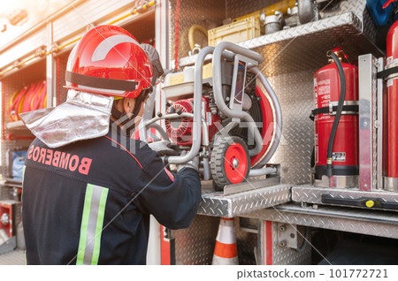 Firefighter check and maintenance equipment for working in area of fireplace office near fire truck 101772721