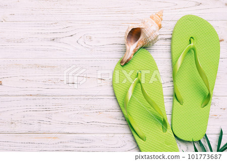 Flat lay composition with flip flops and seashell on colored background. Space for text top view Flat lay composition with flip flops and seashell on colored background. Space for text top view 101773687