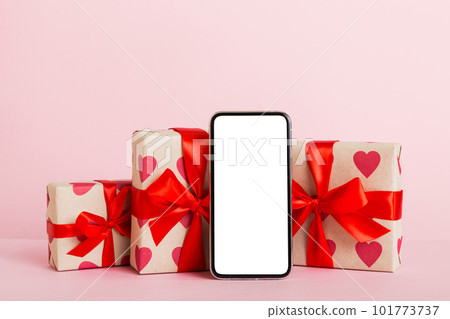 mobile phone with blank screen on colored background with hearts, calendar and gift box, valentine day concept perspertive view flat lay mobile phone with blank screen on colored background with hearts, calendar and gift box, valentine day concept perspertive view flat lay 101773737