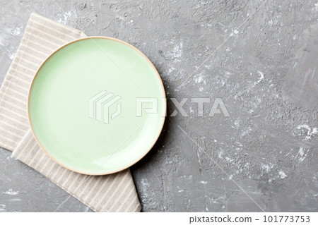 Top view on colored background empty round green plate on tablecloth for food. Empty dish on napkin with space for your design 101773753